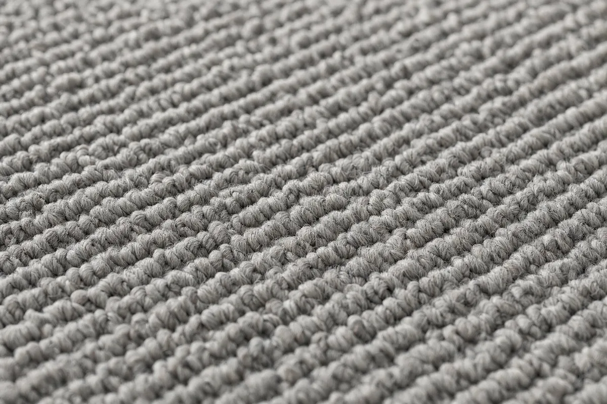Close up of low loop pile carpet texture in soft warm grey with tightly twisted yarn
